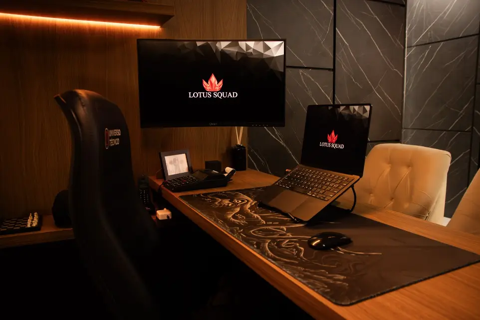 Imagem de notebook com 2 monitores, mousepad grande, modelo macbook.